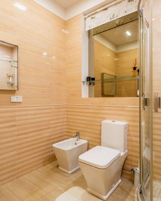 Bathroom with warm timber-effect wall tiles and a glass shower
