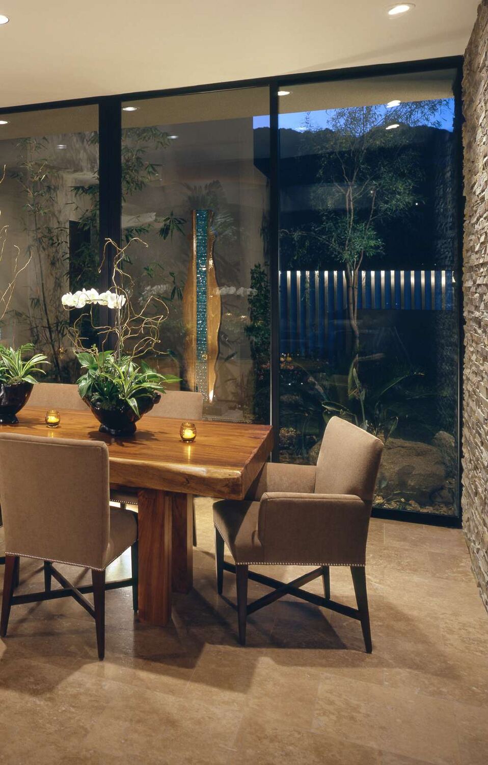 Timber dining table beside a glazed courtyard