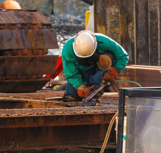 Worker cutting and finishing metal in the workshop